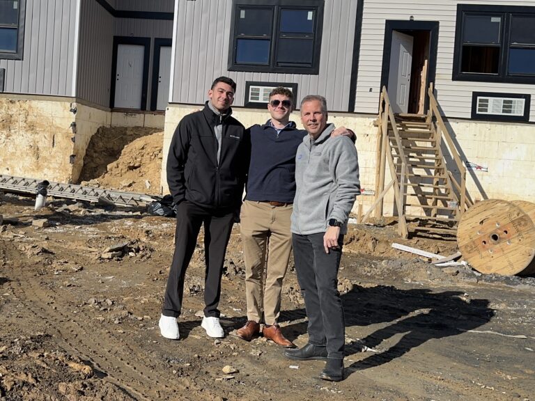 Team photo in front of 16 unit multifamily new construction project